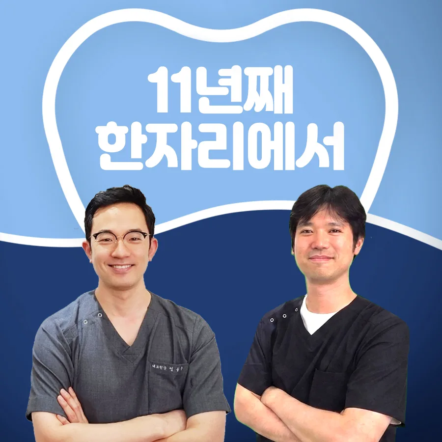 진료복을 입은 치과의사 두 사람이 팔짱을 끼고 선 사진